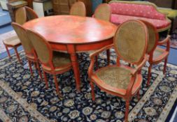 A chinoiserie style red-japanned dining suite, comprising an oval table and a set of eight chairs (