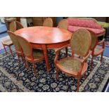 A chinoiserie style red-japanned dining suite, comprising an oval table and a set of eight chairs (