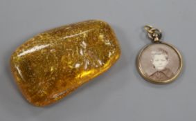 A circular yellow metal locket with photographic portrait and lock of hair verso and a piece of