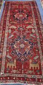 A Caucasian red ground hall carpet 257 x 109cm