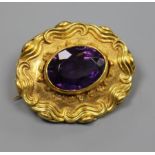 A late Victorian ornate yellow metal and amethyst set oval brooch, 40mm