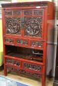 A Chinese red lacquered carved hardwood cupboard W.104cm