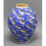 A large Studio pottery vase of ovoid form, decorated all over with fish swimming on a blue ground