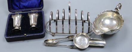 A silver sauceboat, a cased pair of silver condiments, a silver toastrack and three other silver