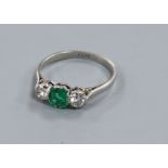 A platinum, emerald and diamond three stone ring, size O.