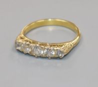 A yellow metal and graduated five stone diamond half hoop ring, size N.