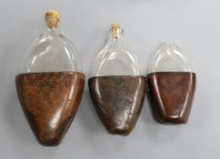 Three 18th century and later leather cased glass flasks, largest 20cm