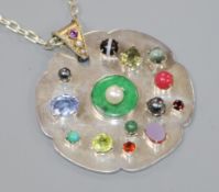 A bespoke white metal and multi gem set shaped circular pendant, on a white metal chain, pendant