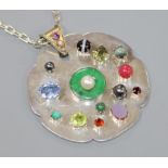 A bespoke white metal and multi gem set shaped circular pendant, on a white metal chain, pendant