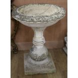 A reconstituted garden bird bath, raised on a square plinth W.61cm