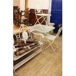 A four piece white painted garden suite, consisting of a square topped table, a bench and a pair