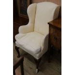 An upholstered wing armchair