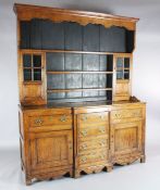 A George III oak breakfront dresser, the associated three shelf rack with two glazed doors, over