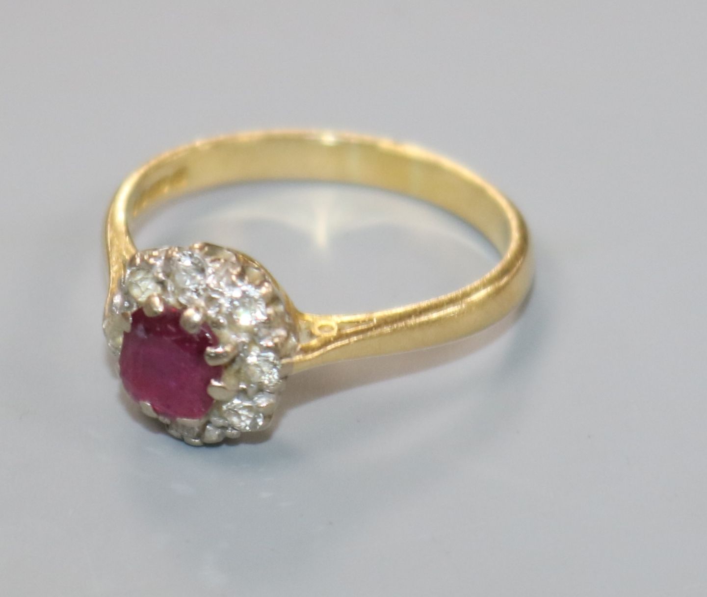 A modern 18ct gold, ruby and diamond cluster ring, size P/Q.