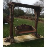 A large Florentine style carved wood garden swing This lot may be viewed on site at a property at