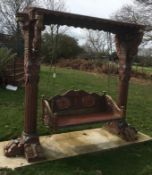 A large Florentine style carved wood garden swing This lot may be viewed on site at a property at