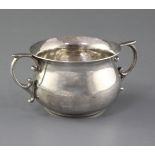 A modern silver two handled sugar bowl by Rodney C. Pettit, of plain baluster form, with scroll