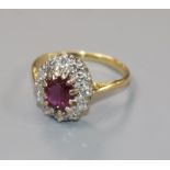 An 18ct gold, ruby and diamond oval cluster ring, size L.