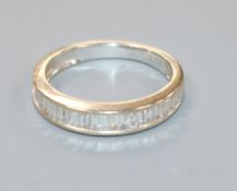 An 18ct white gold and baguette cut diamond set half eternity ring, size J.