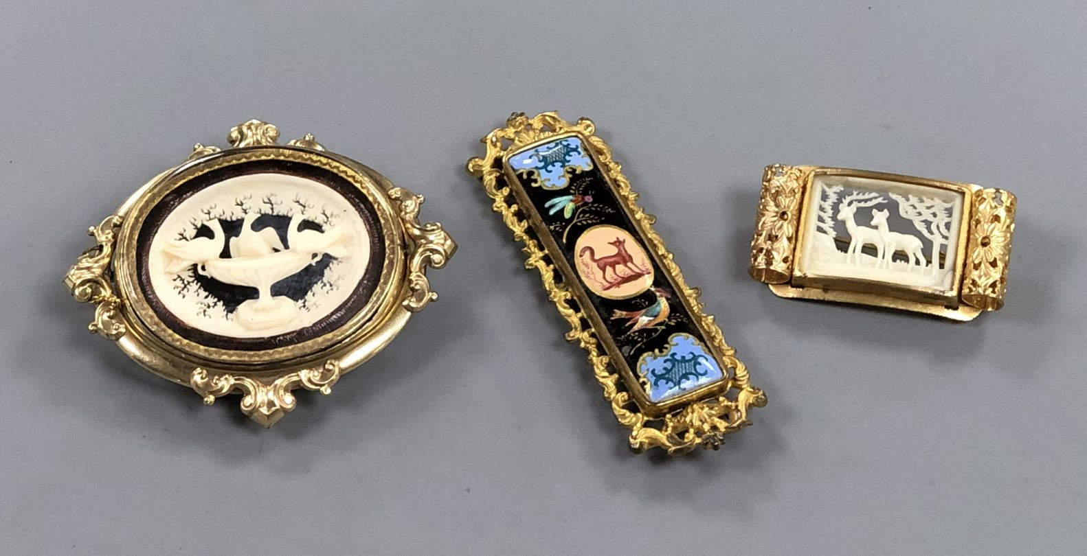 A Victorian pinchbeck 'Pliny Doves' swivelling brooch and two other gilt metal brooches including
