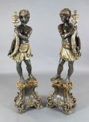 A pair of Italian parcel silvered painted wood blackamoors, each standing holding a cornucopia, H.