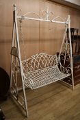 A white painted wrought iron garden swing seat W.160cm