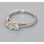 A modern 18ct white gold and three stone diamond ring, size M.