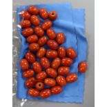 Thirty-eight Chinese glass coral coloured beads
