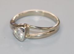 An 18ct white gold and collet set solitaire diamond ring, size L.