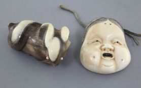 Two Japanese netsuke, the first of an ivory mask of Okame, Meiji period, stained detail and two