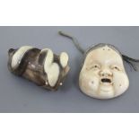 Two Japanese netsuke, the first of an ivory mask of Okame, Meiji period, stained detail and two