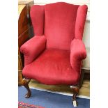 A Queen Anne style upholstered wing armchair on walnut cabriole legs