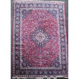 A Meshed red and blue ground, carpet 5.03 x 3.43 with central medallion in a field of floral motifs,