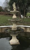 A reconstituted stone three tier garden fountain, surmounted by a putti holding a dolphin This lot