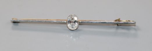 A yellow metal and solitaire oval cut diamond set bar brooch, the stone weighing approximately 0.