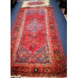 A Caucasian design red ground rug and a mat 186 x 100cm and 90 x 49cm