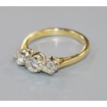A modern 18ct gold and three stone diamond ring, size L.