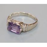 An 18ct white gold and emerald cut amethyst ring with diamond set shoulders, size P.