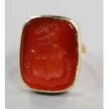 A yellow metal and carved carnelian intaglio ring, size F.