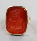 A yellow metal and carved carnelian intaglio ring, size F.