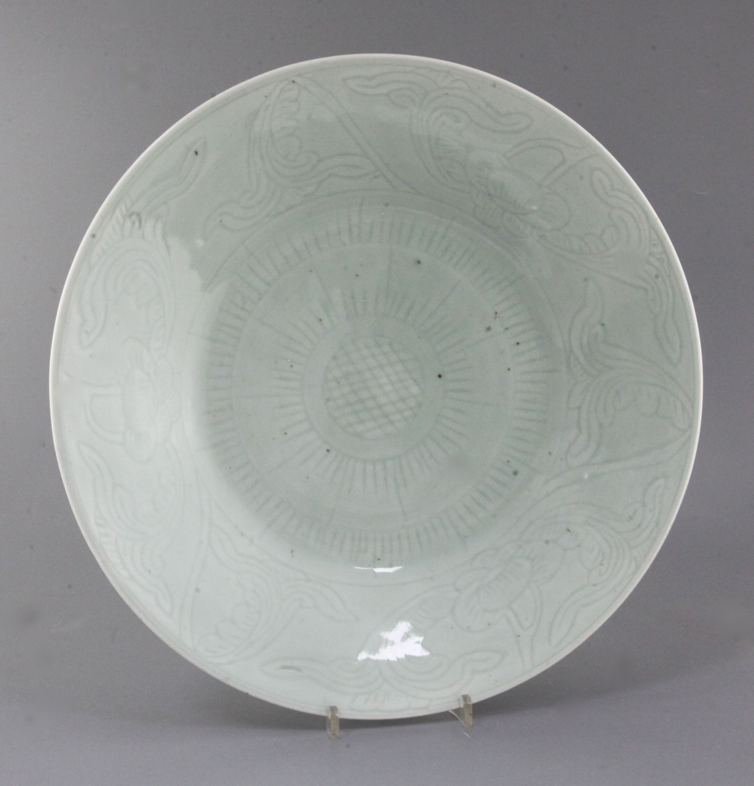 A Chinese celadon glazed dish, 19th century, the centre incised with a flowerhead, 5the borders with