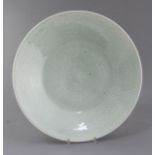 A Chinese celadon glazed dish, 19th century, the centre incised with a flowerhead, 5the borders with