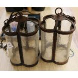 A pair of wrought iron and glass lanterns