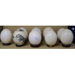 Nine ostrich eggs, on stands