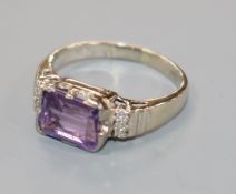 An 18ct white gold and emerald cut amethyst ring with diamond set shoulders, size P.