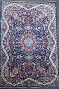 A Tabriz blue ground carpet, with field of scrolling geometric motifs and wavy border,