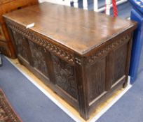 An 18th century oak coffer, with three panel carved front, W.130cm