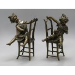 A pair of novelty bronze bookends of girls playing on chairs height 20cm