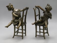 A pair of novelty bronze bookends of girls playing on chairs height 20cm