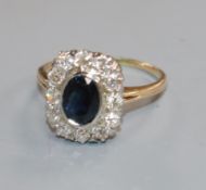A yellow metal, sapphire and diamond set shaped oval cluster ring, size M.